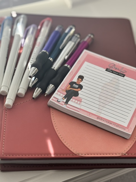 Paper planning setup with colorful pens and a notepad for writing tasks, reminders, and daily ideas.