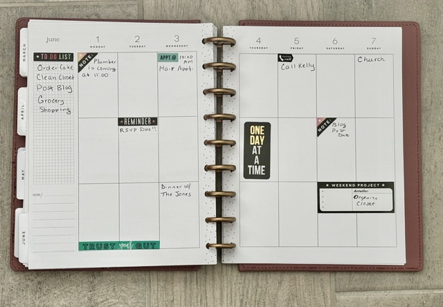 Disc-bound paper planner with a weekly layout, functional stickers, and handwritten tasks for organizing daily plans.